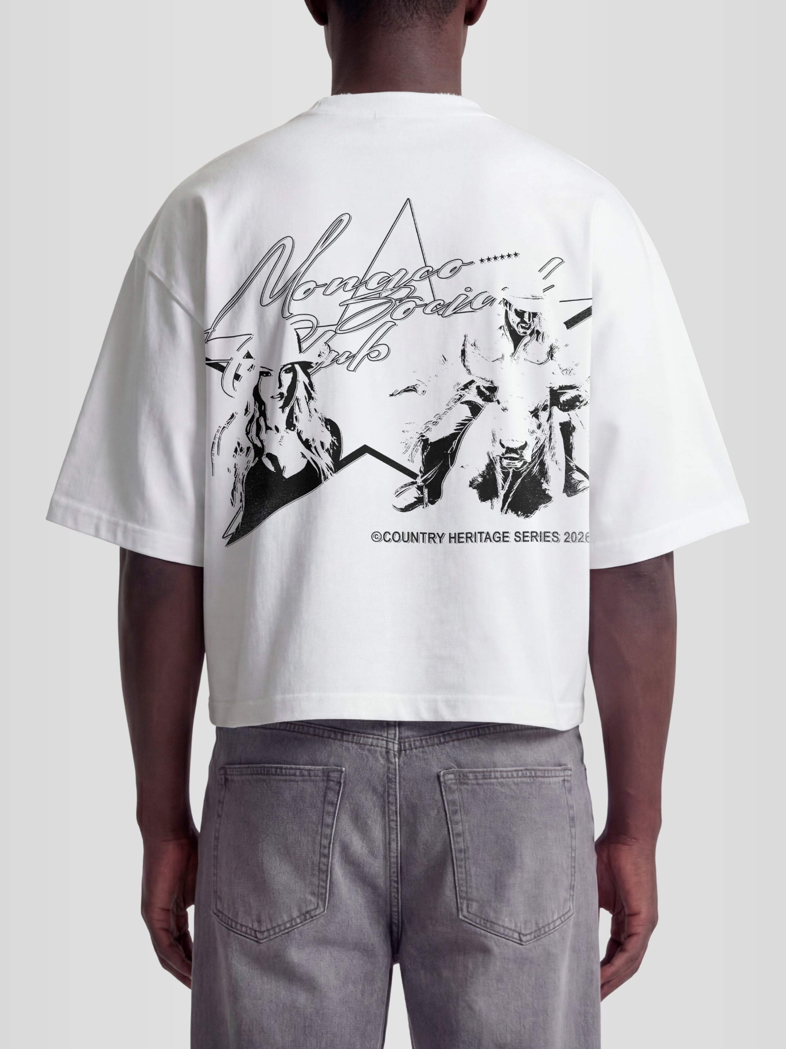 Man model wearing the Rodeo Heavyweight Boxy Tee in White with cowgirl and bull rider western graphic — Monaco Social Club Country Heritage Series streetwear