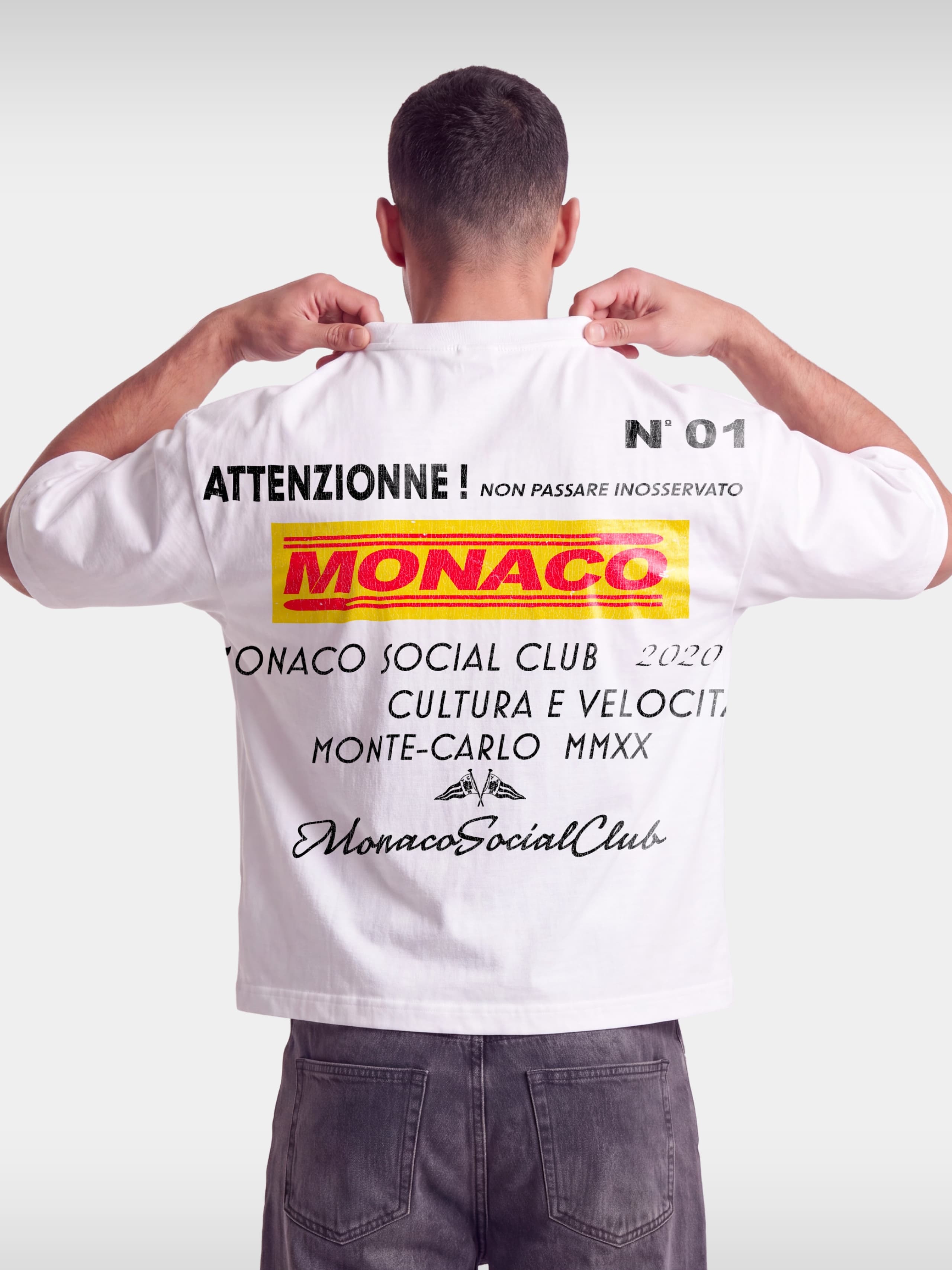 Monaco Trackside white boxy tee worn by model, back view with red and yellow MONACO racing print.