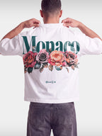 Monaco Bloom white boxy tee worn by model, back view with green Monaco wordmark and roses.