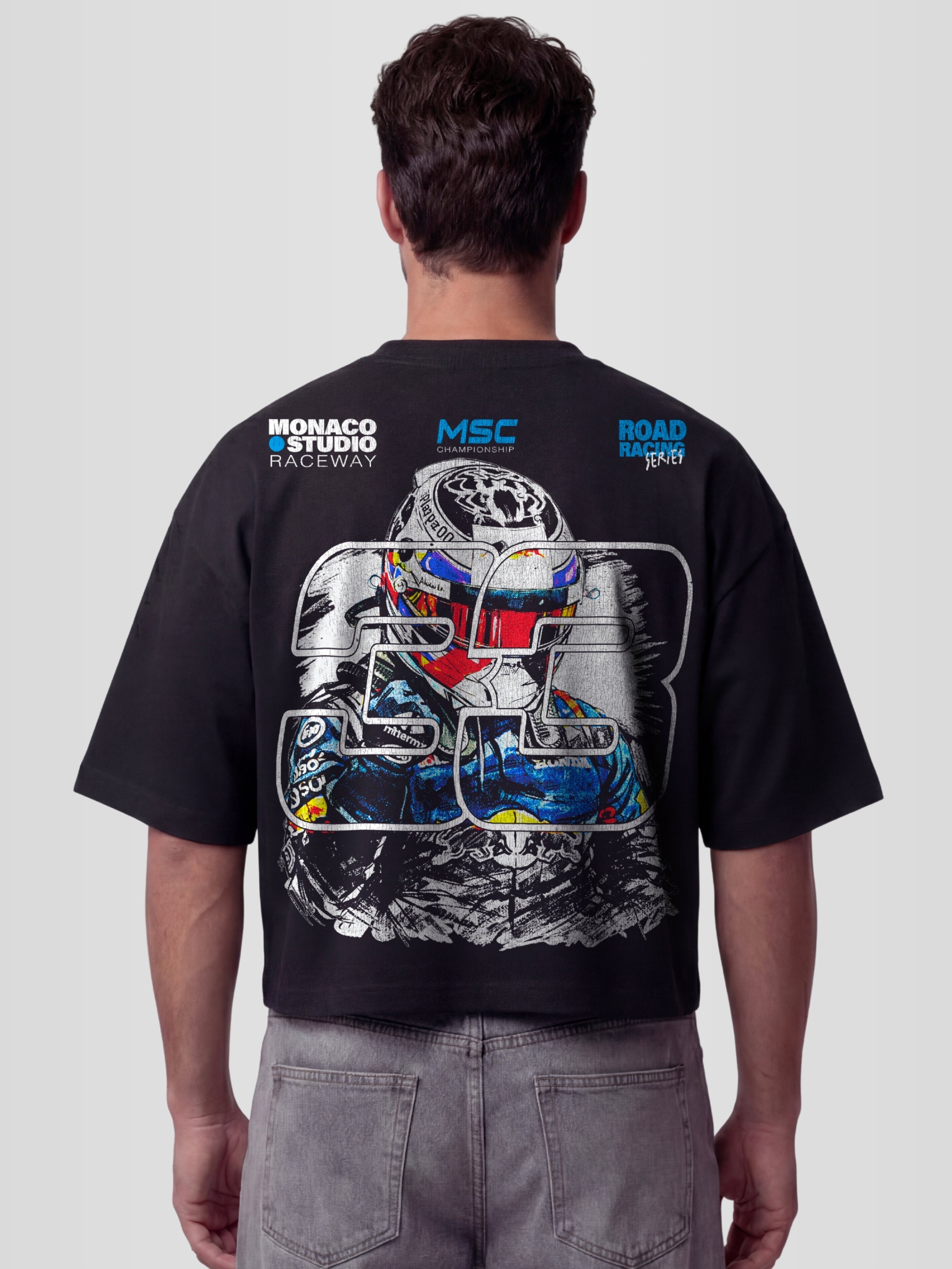 Model wearing the #33 Racing Series Heavyweight Boxy Tee in Black with full-color sketched racing driver portrait and MSC Championship badges — Monaco Social Club streetwear