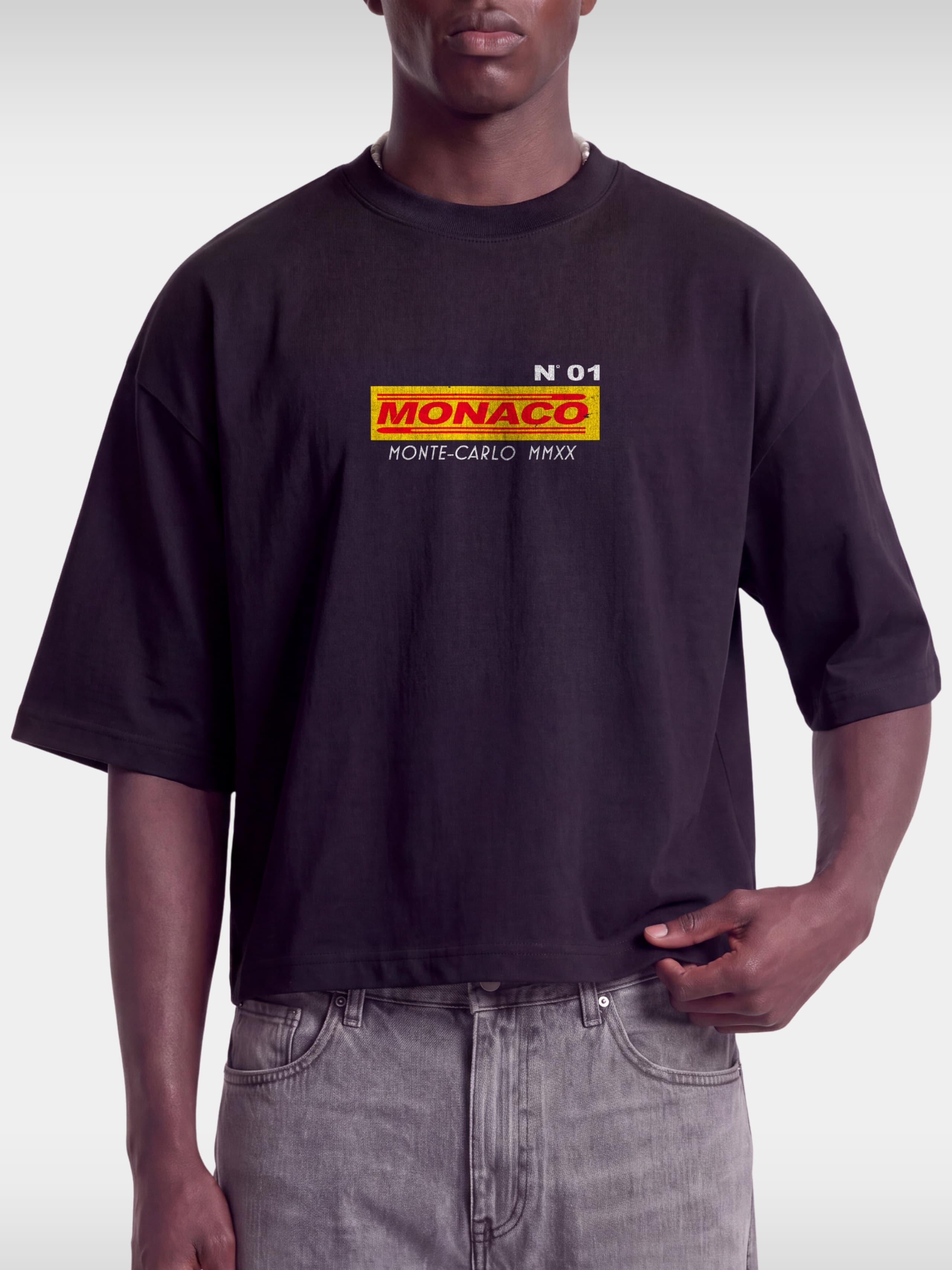 Black Trackside boxy tee on model, front view with No. 01 and MONACO racing box logo on chest.