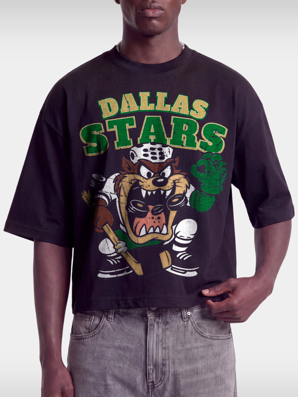 Black Dallas Stars Taz boxy tee on model, front view with green and gold arched team lettering.