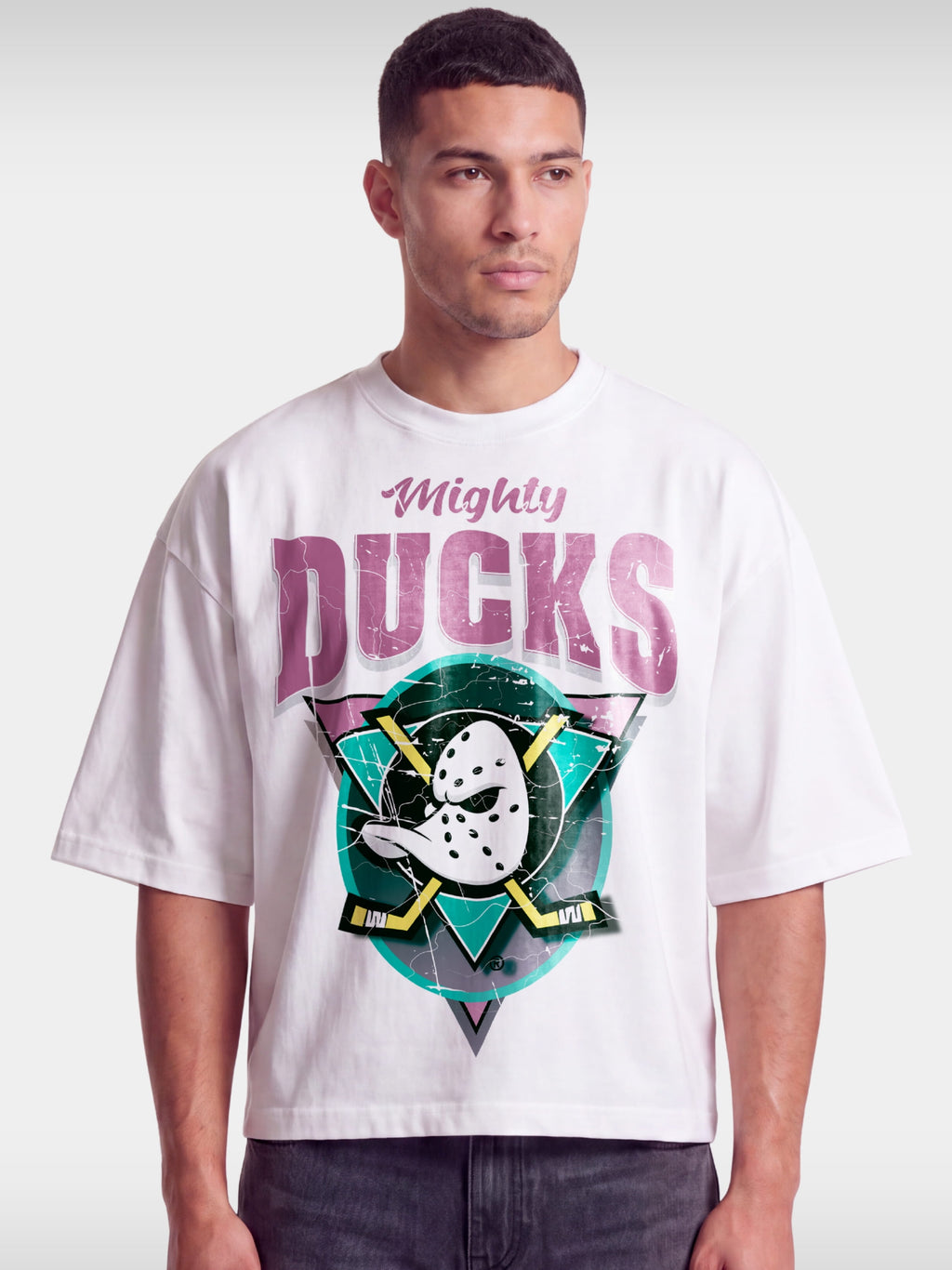 White Mighty Ducks boxy tee worn by model, front view with duck goalie mask and crossed sticks.