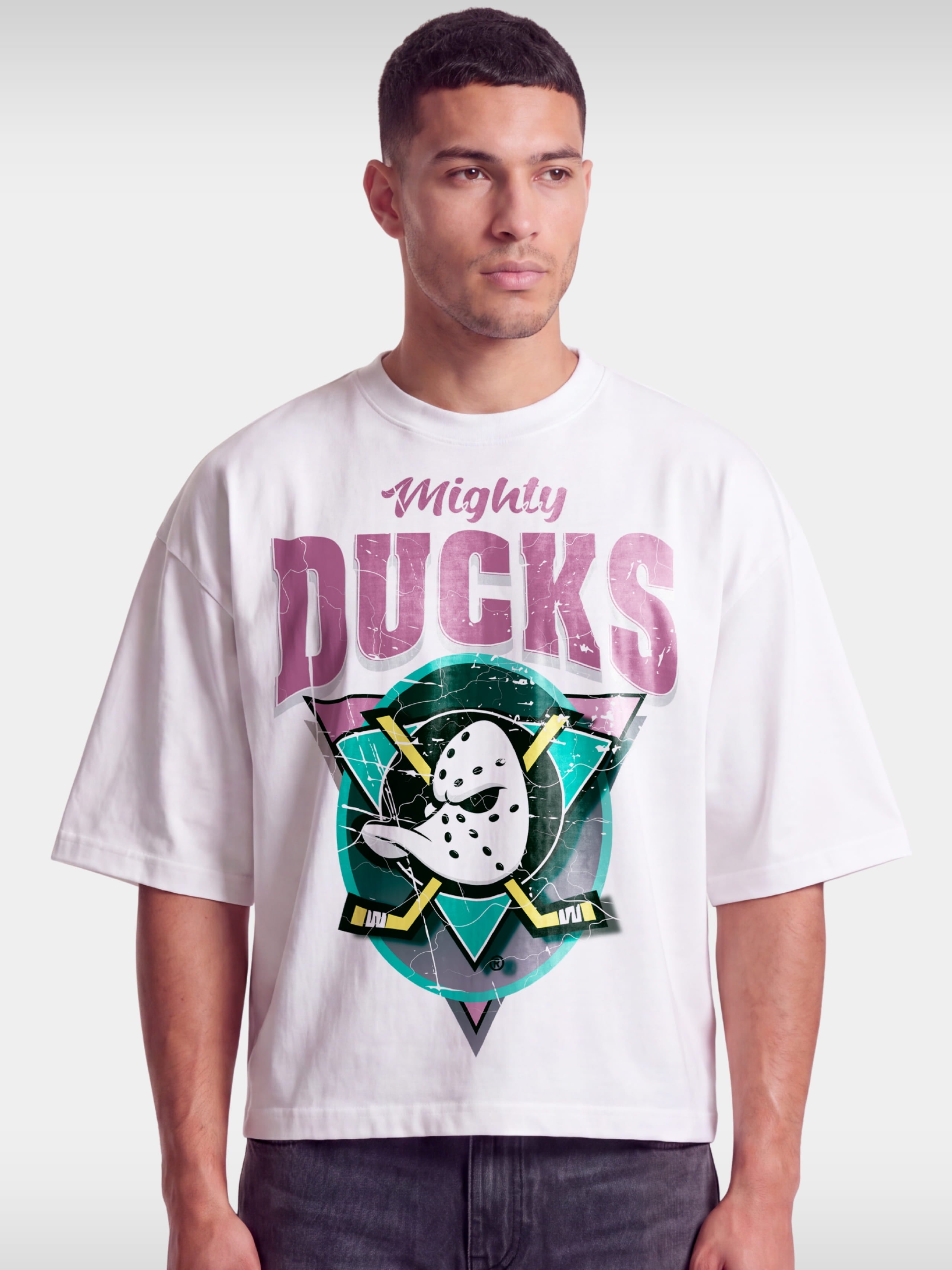 White Mighty Ducks boxy tee worn by model, front view with duck goalie mask and crossed sticks.