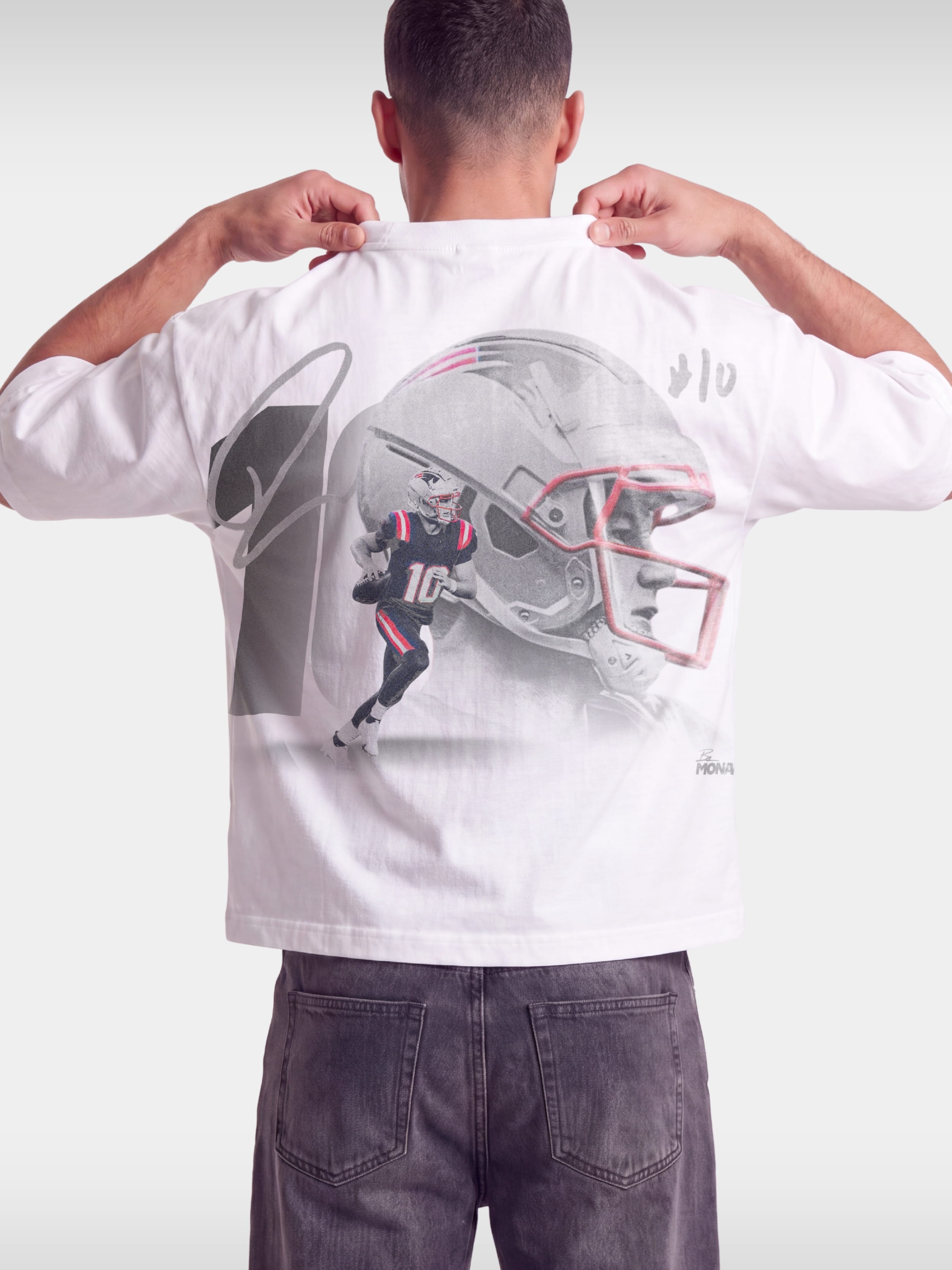 Monaco No. 10 Franchise tee in white worn by model, back view with oversized football helmet graphic.