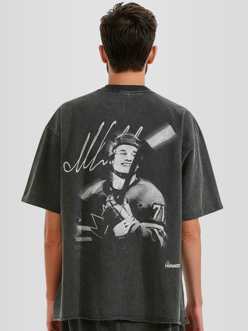 Man model wearing the Celebrini Legacy Blur Heavyweight Raw Hem Tee with motion blur hockey graphic — Monaco Social Club streetwear