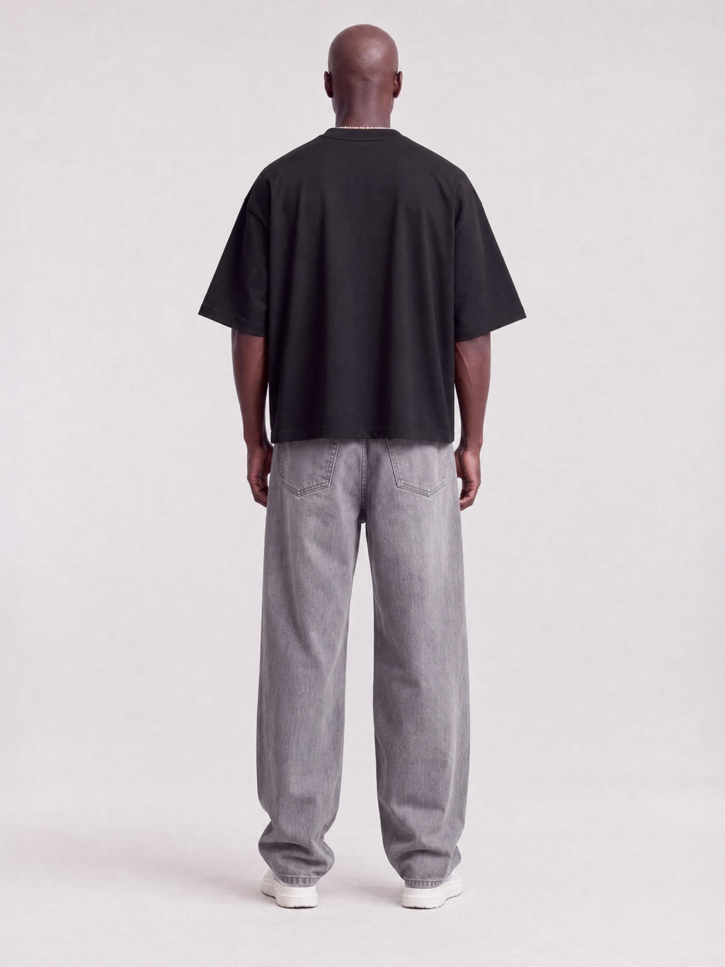 Monaco black boxy tee worn by model, full-length back view showing boxy fit and drop shoulders.