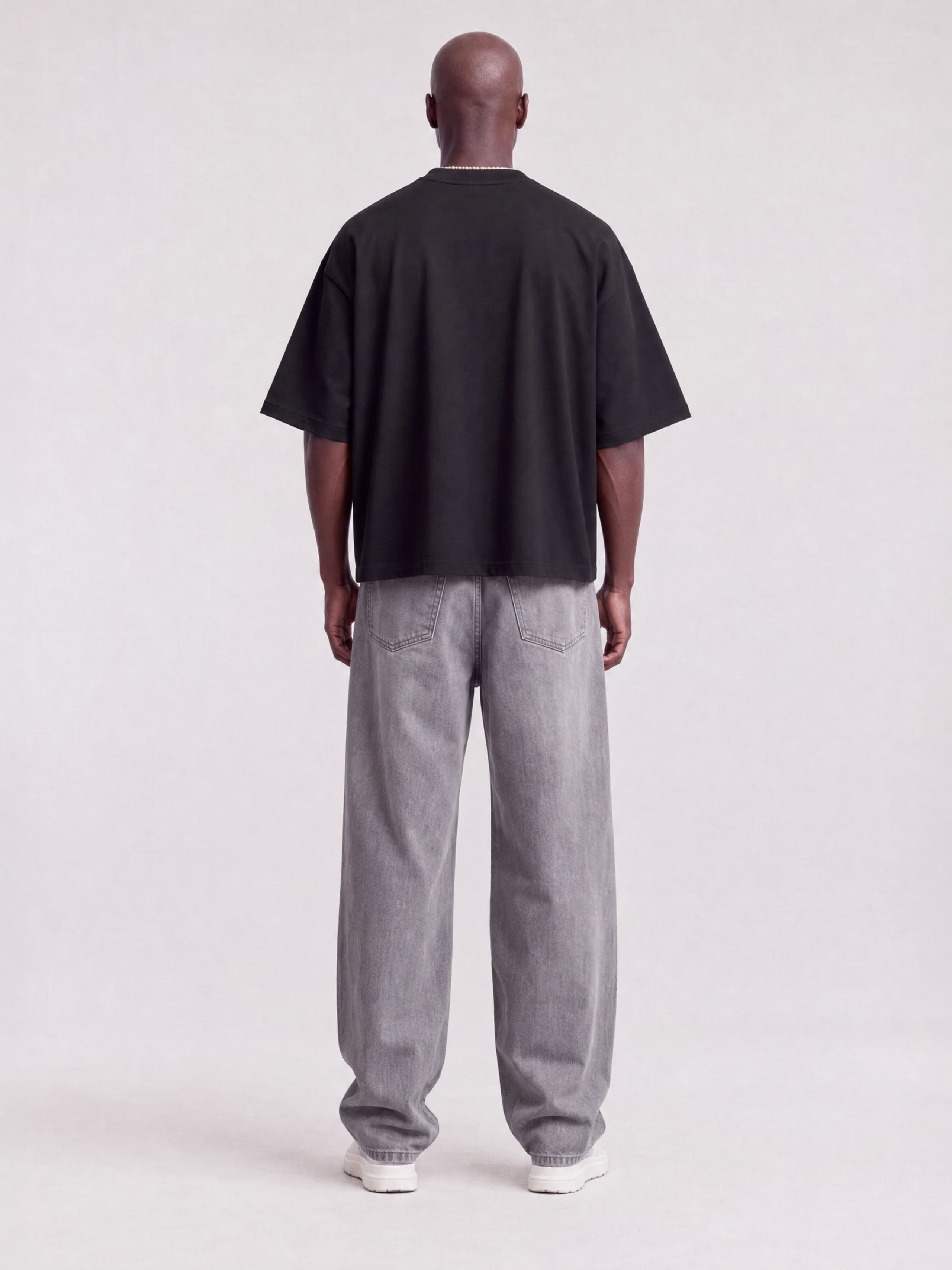 Monaco black boxy tee worn by model, full-length back view showing boxy fit and drop shoulders.