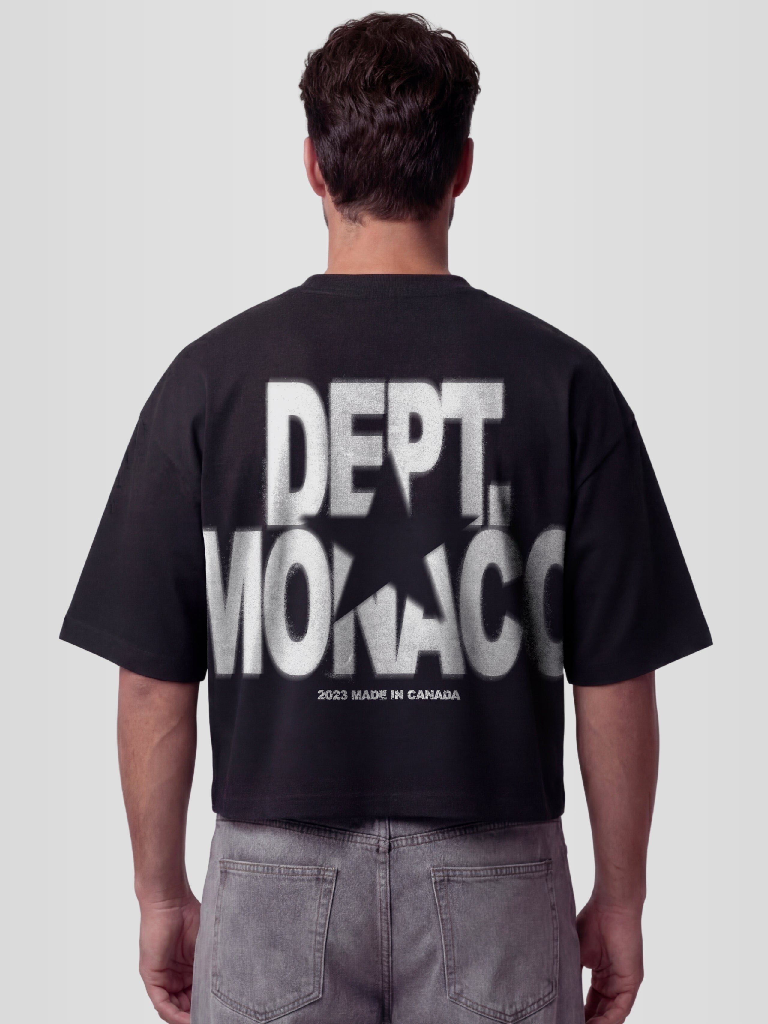 Man model wearing the Blur Dept. Heavyweight boxy tee in Black with stacked Monaco typography and star graphic — Monaco Social Club streetwear