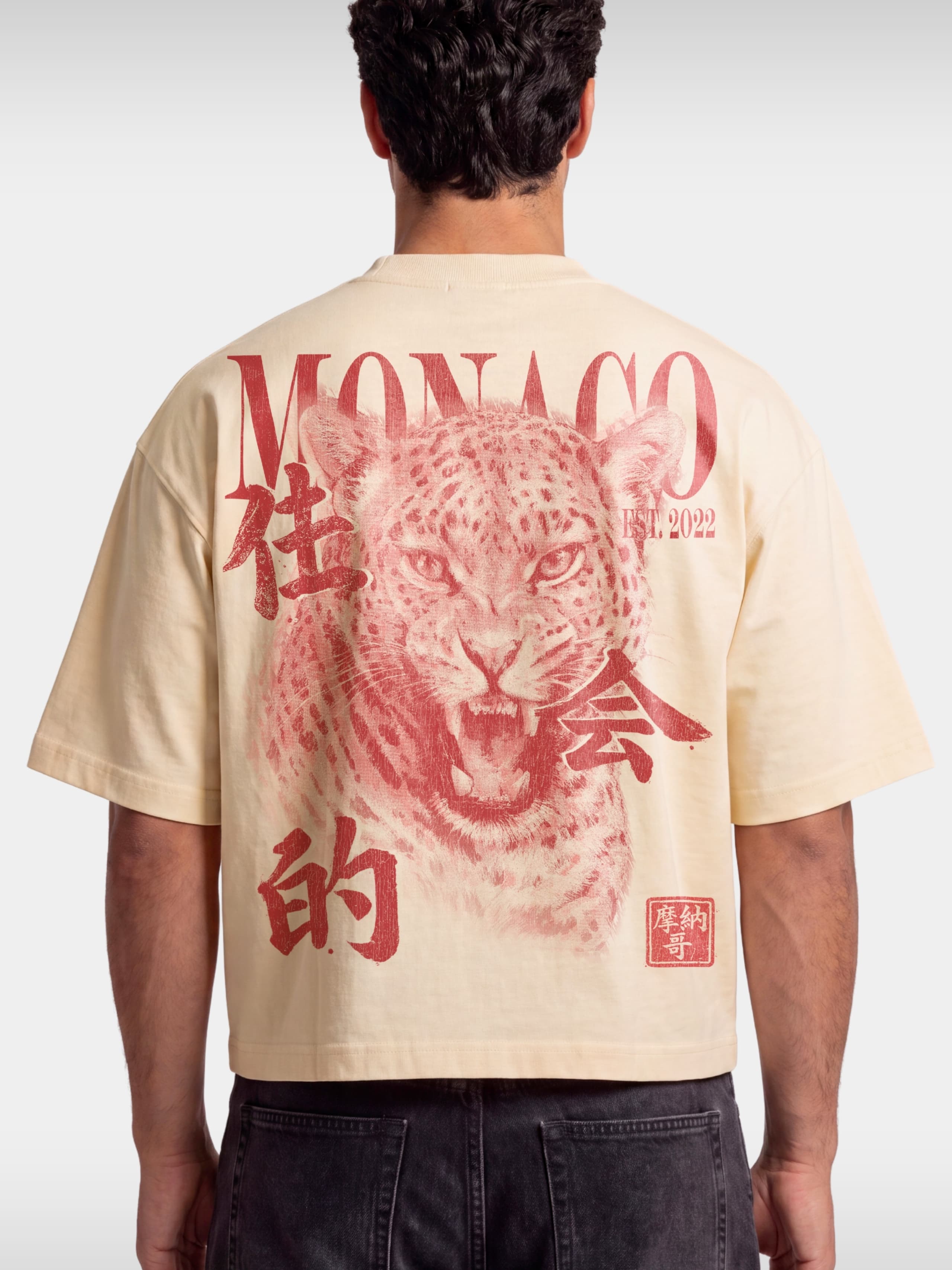 Monaco Primal Instinct ivory boxy tee worn by model, back view with red leopard graphic.
