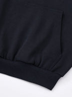 Black Monaco athleisure hoodie detail showing kangaroo pocket stitching and ribbed waistband.