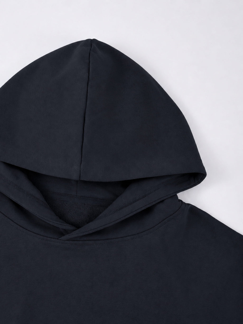 Black Monaco athleisure hoodie close-up showing structured hood construction and smooth fabric.