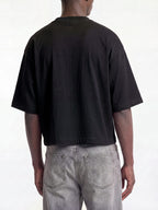 Black Monaco boxy tee on model, back view showing drop-shoulder sleeves and cropped hem.