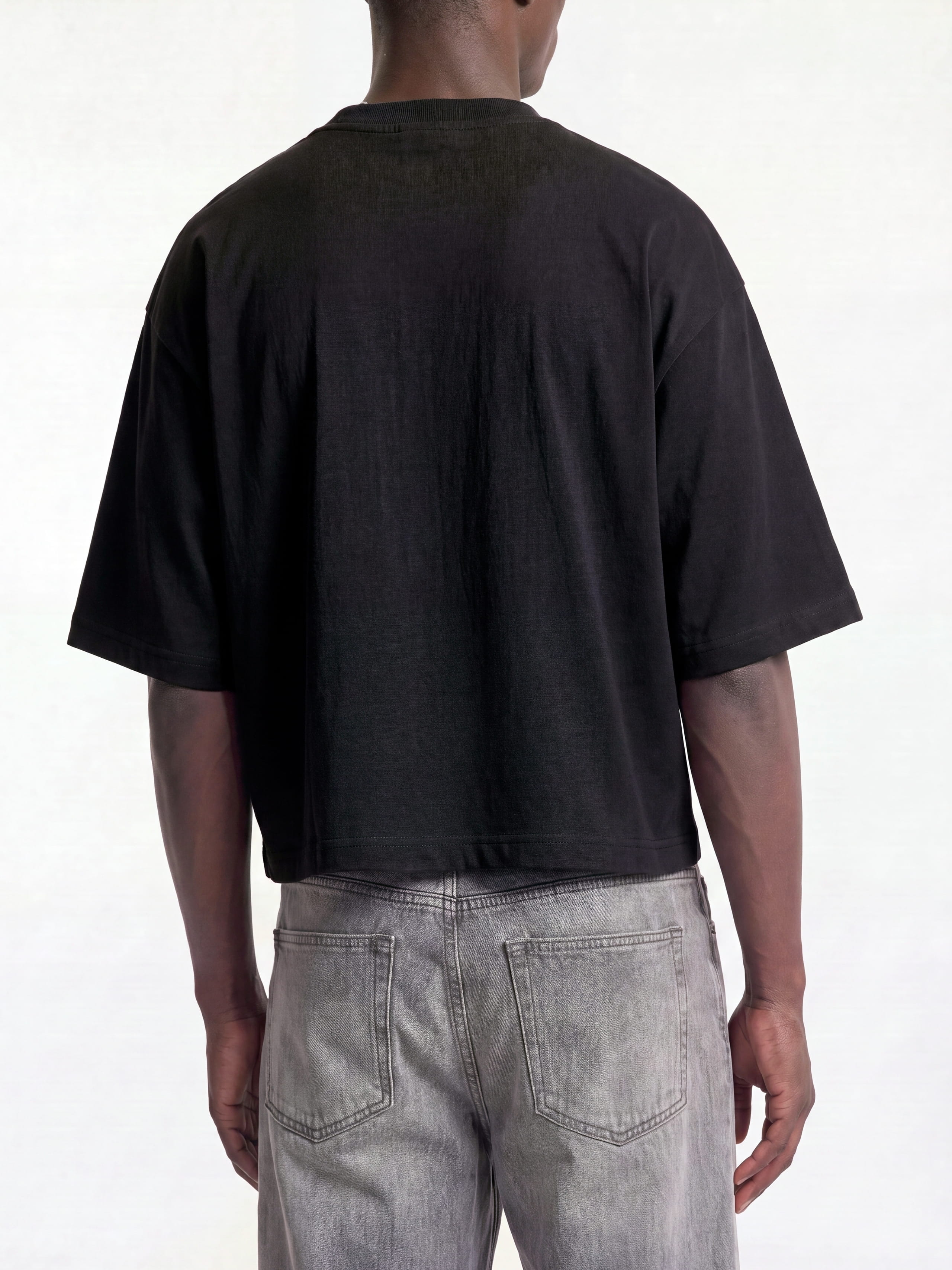 Black Monaco boxy tee on model, back view showing drop-shoulder sleeves and cropped hem.