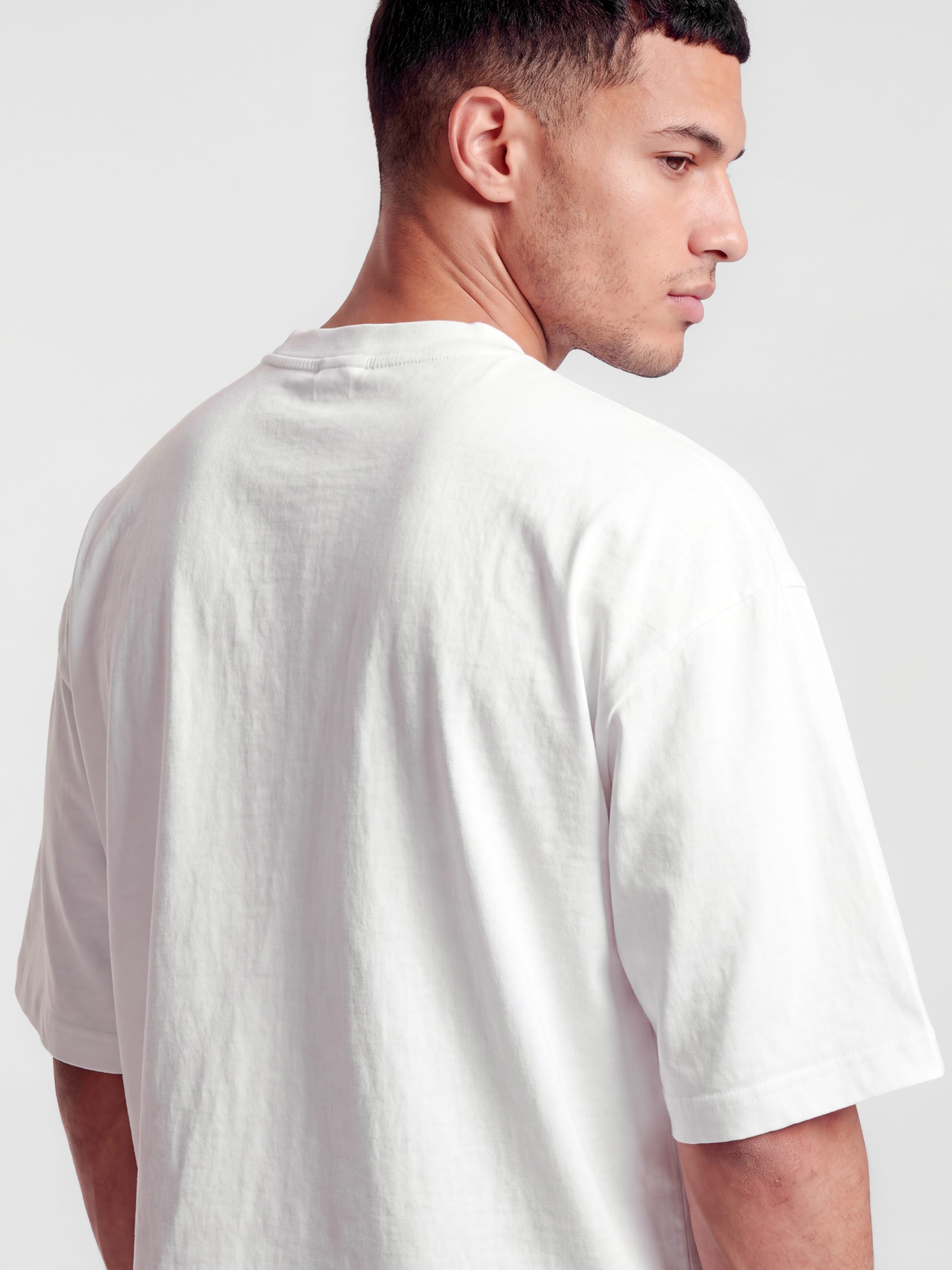 Close-up back view of Monaco white boxy tee on model, showing shoulder seam and cotton fabric.