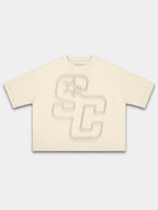Ivory Club boxy tee by Monaco, front view with faded beige SC monogram and star graphic.