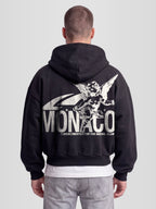 Man model wearing The saint double zip hoodie. Heavyweight Full-Zip Hoodie in black with back graphic — Monaco Social Club streetwear