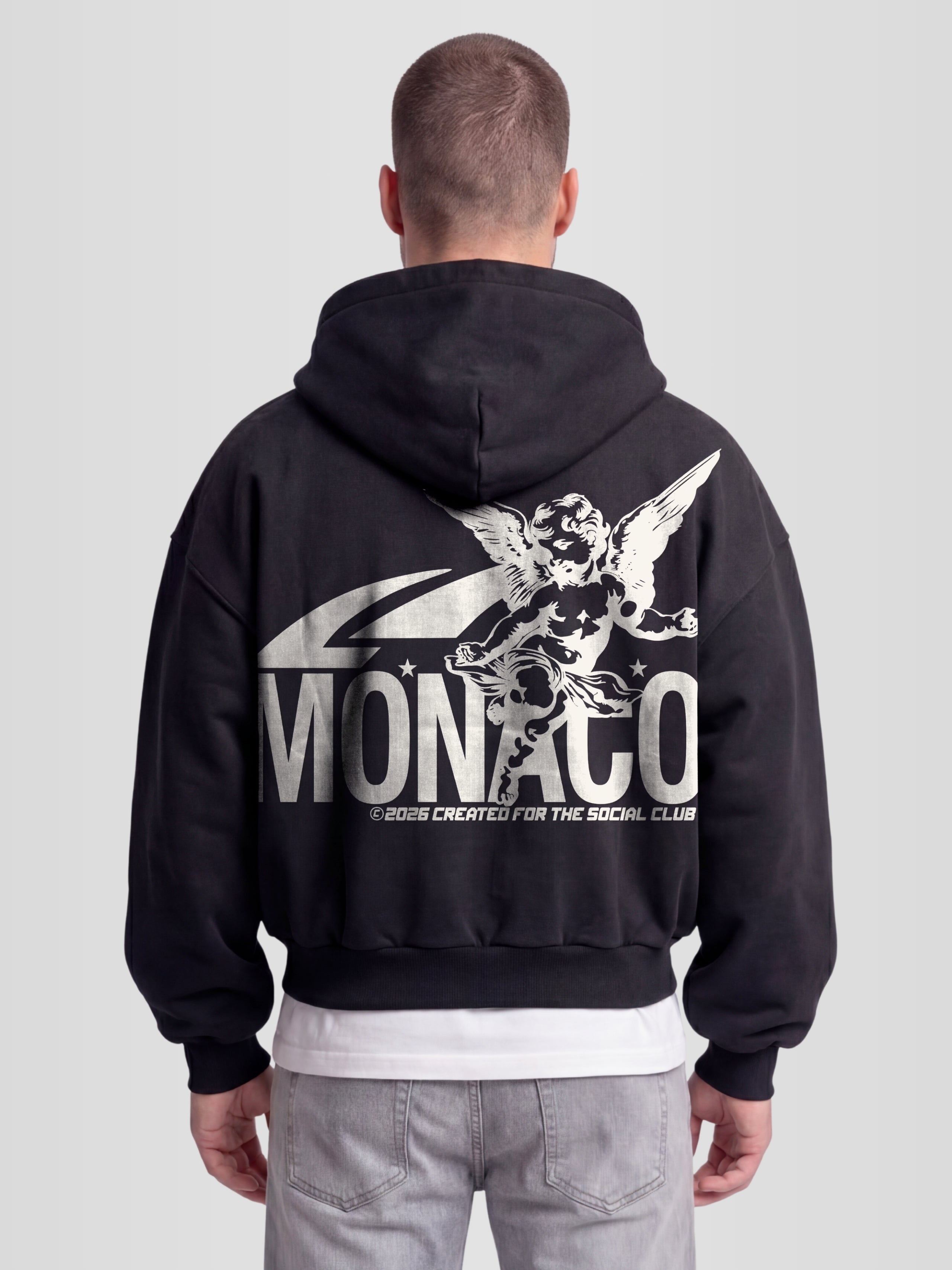 Man model wearing The saint double zip hoodie. Heavyweight Full-Zip Hoodie in black with back graphic — Monaco Social Club streetwear