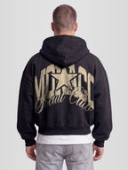 Model wearing The Varsity Heavyweight Full-Zip Hoodie in Black with arched Monaco graphic — Monaco Social Club streetwear