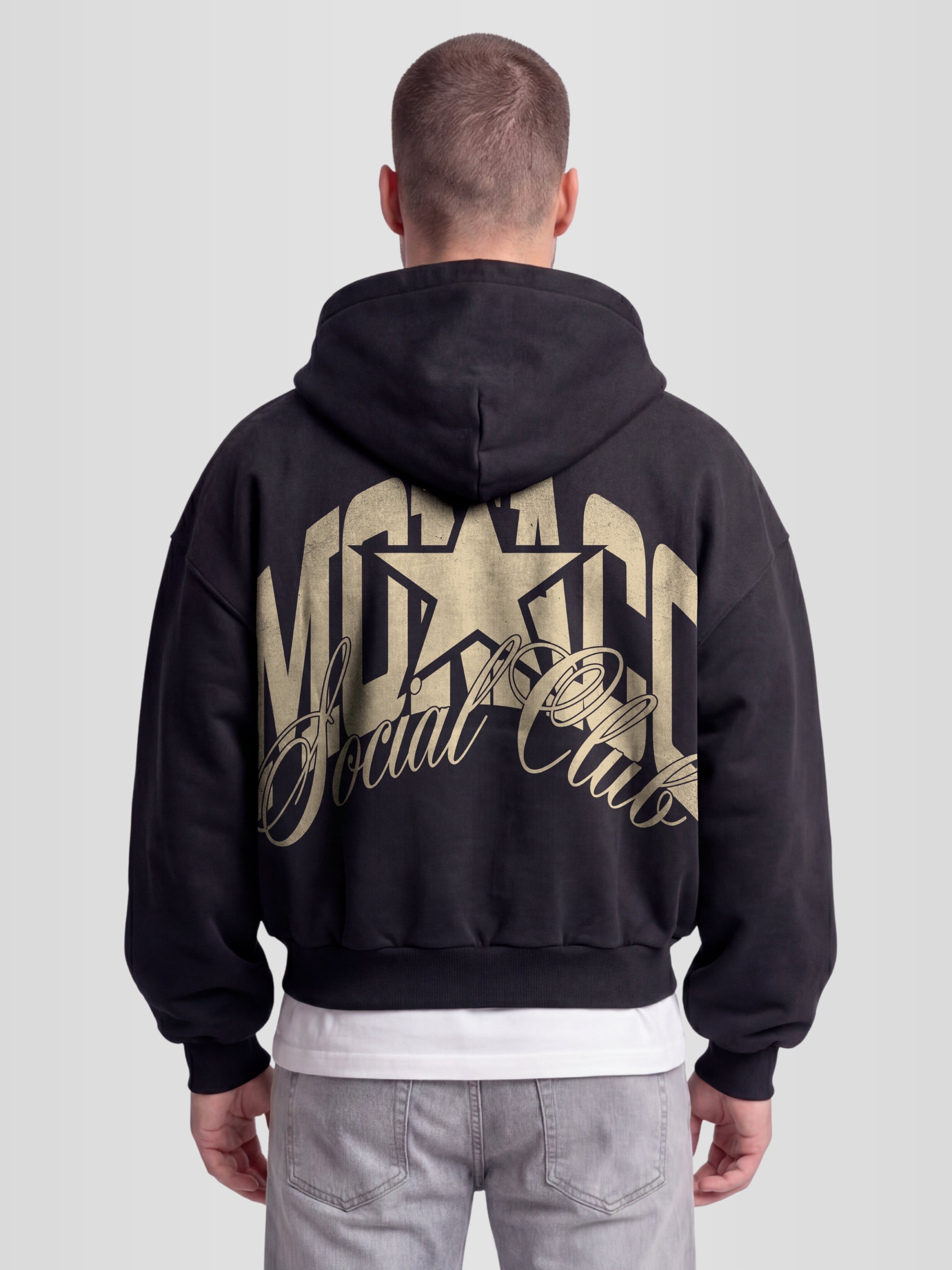 Model wearing The Varsity Heavyweight Full-Zip Hoodie in Black with arched Monaco graphic — Monaco Social Club streetwear