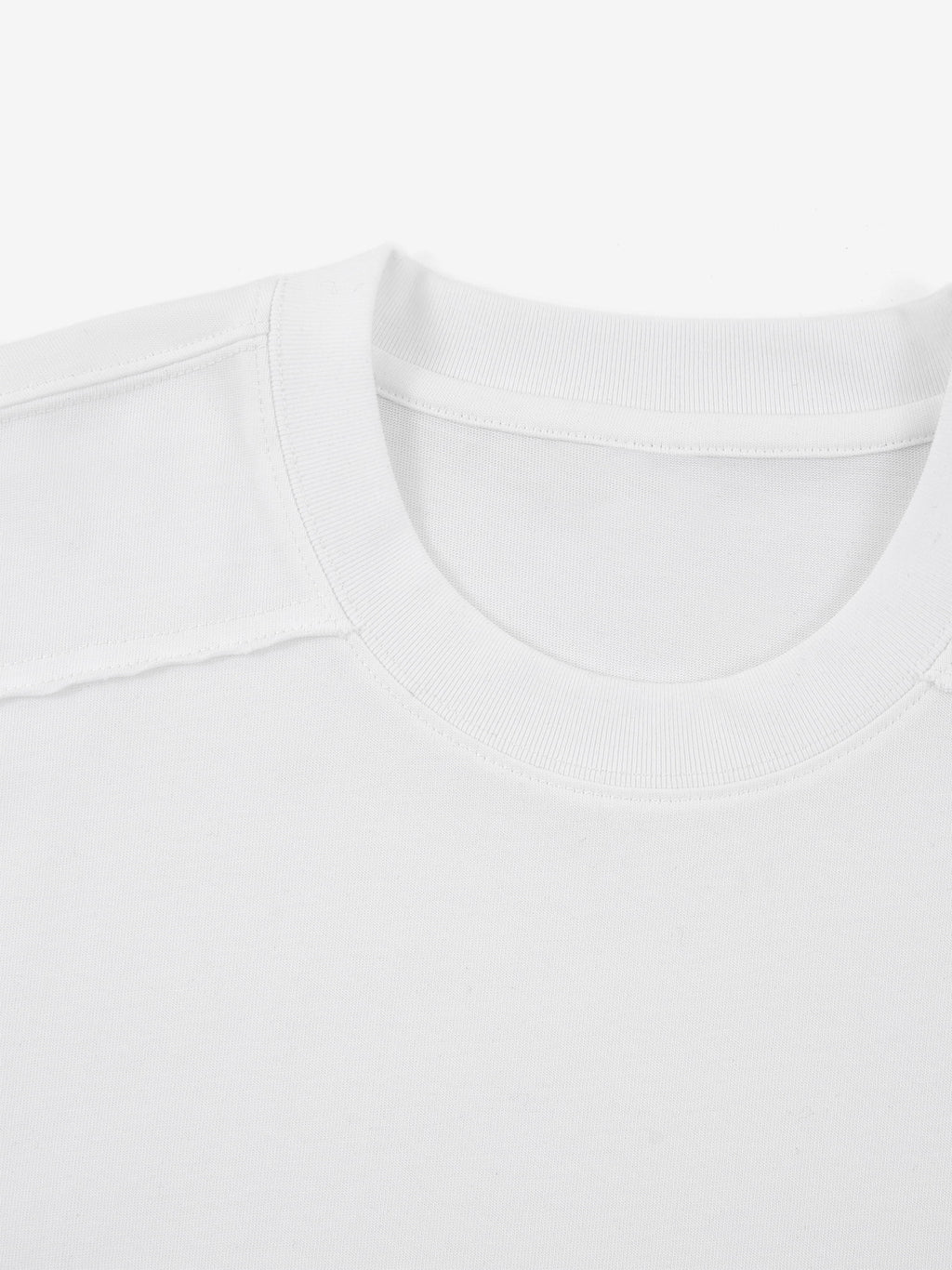White Monaco paneled shirt close-up showing ribbed crew neck and structured shoulder seam.