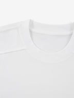 White Monaco paneled shirt close-up showing ribbed crew neck and structured shoulder seam.