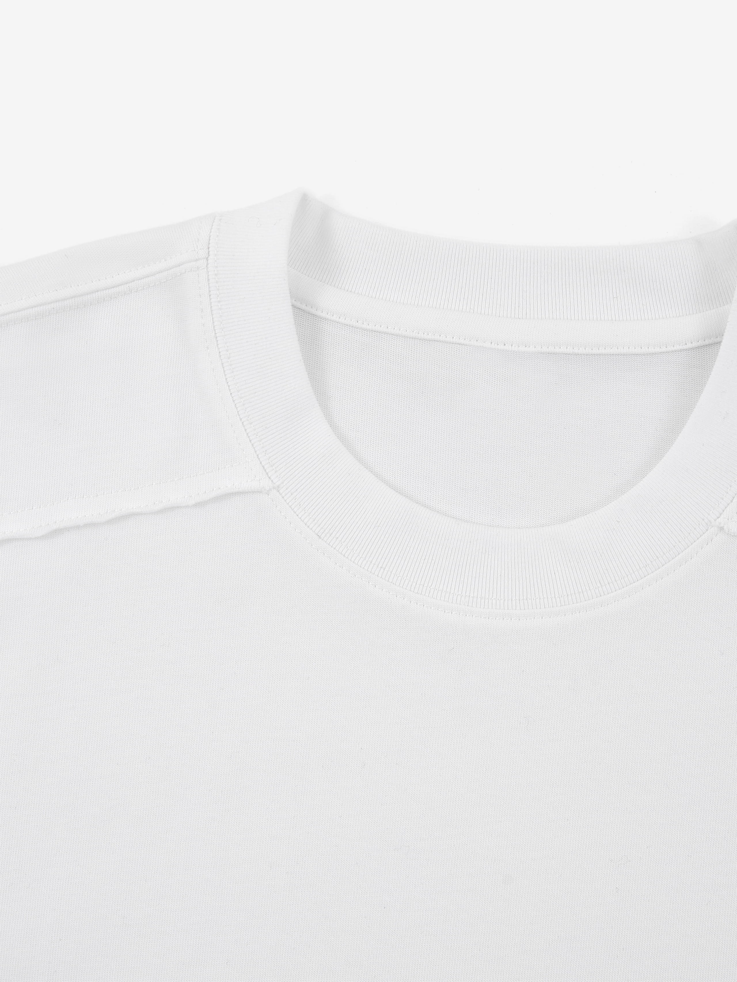 White Monaco paneled shirt close-up showing ribbed crew neck and structured shoulder seam.