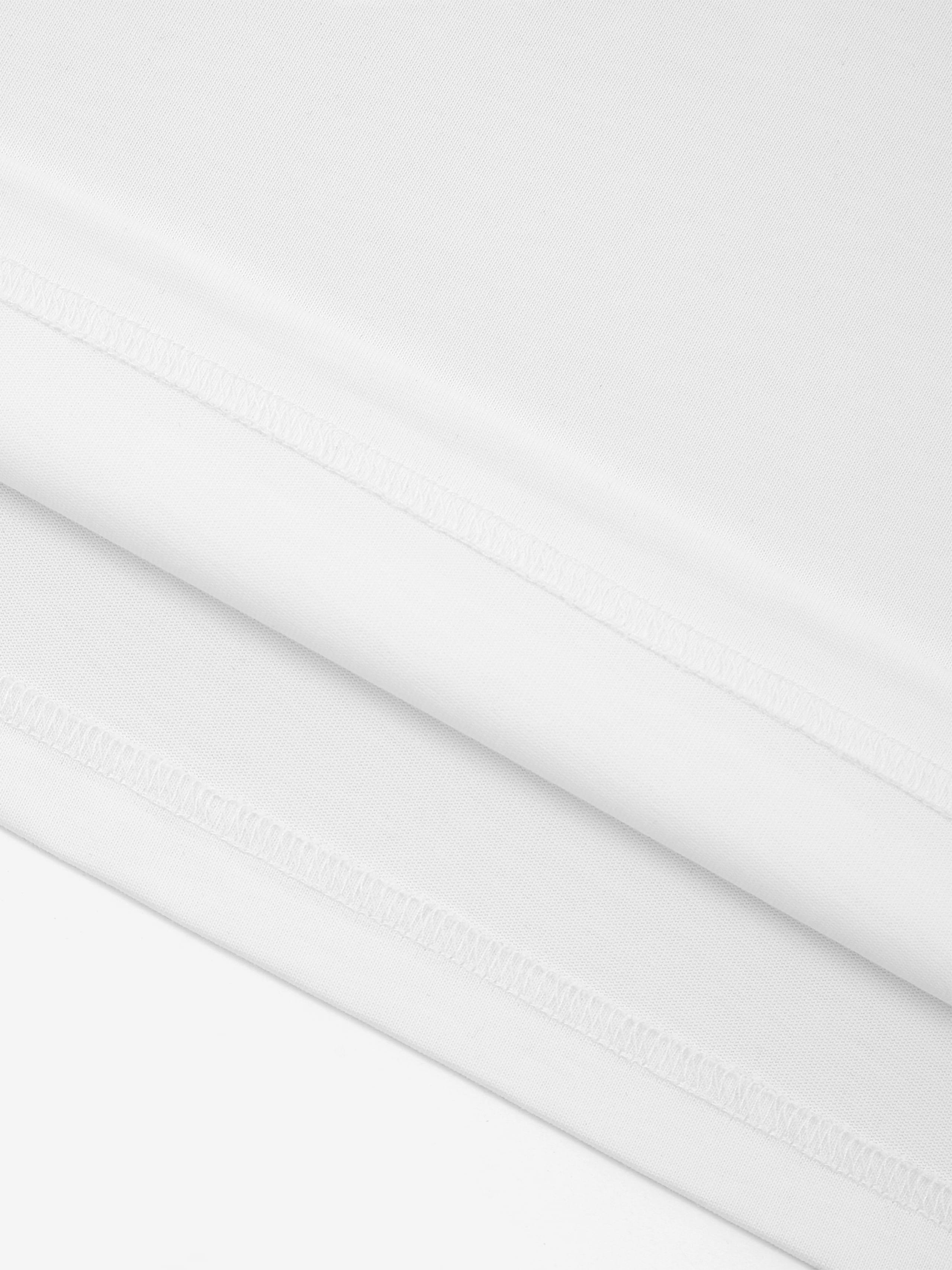 White Monaco 100% cotton paneled shirt close-up showing fabric texture and interior seam stitching.