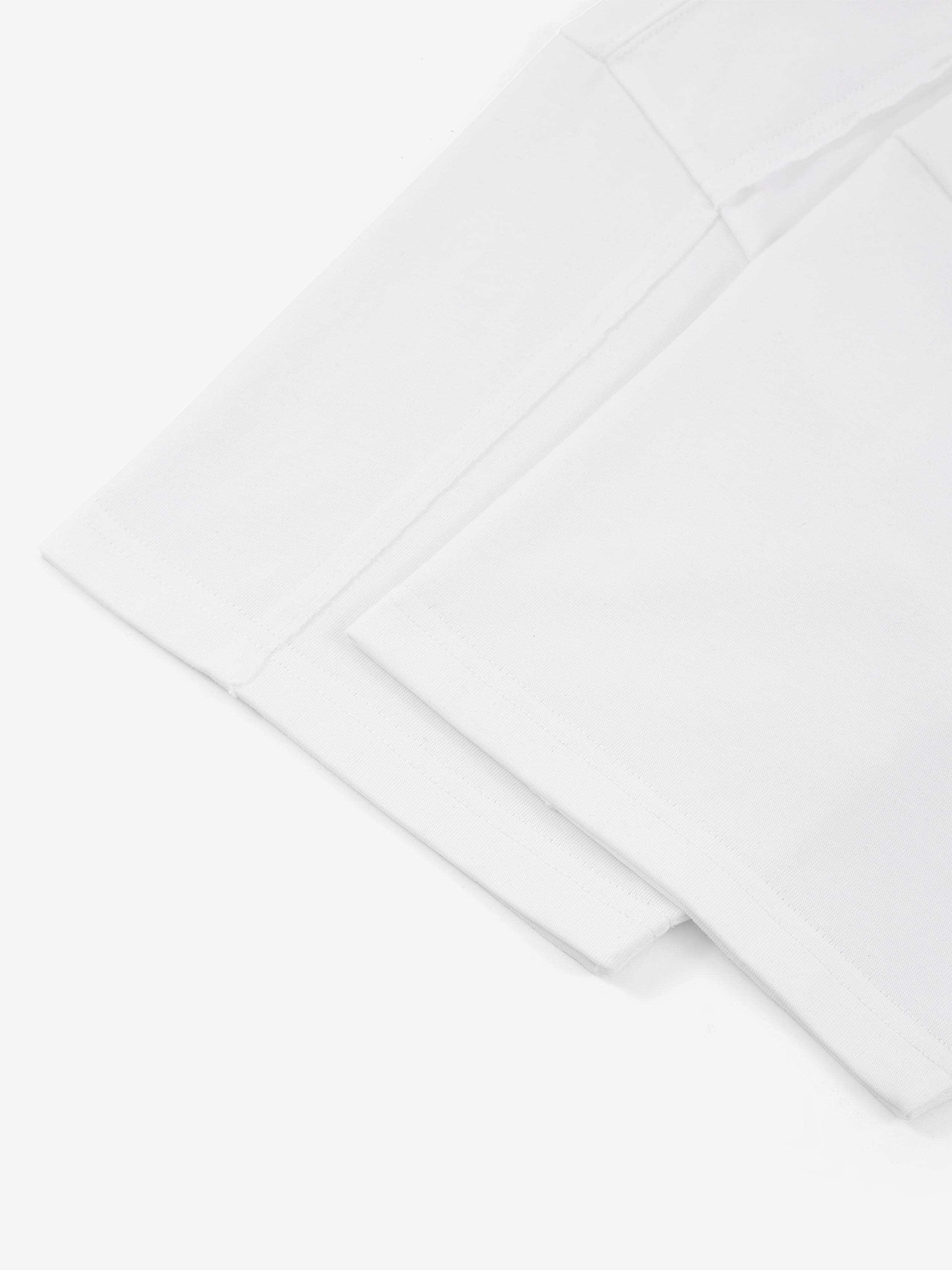White Monaco paneled shirt detail showing sleeve hem and structured panel seam.